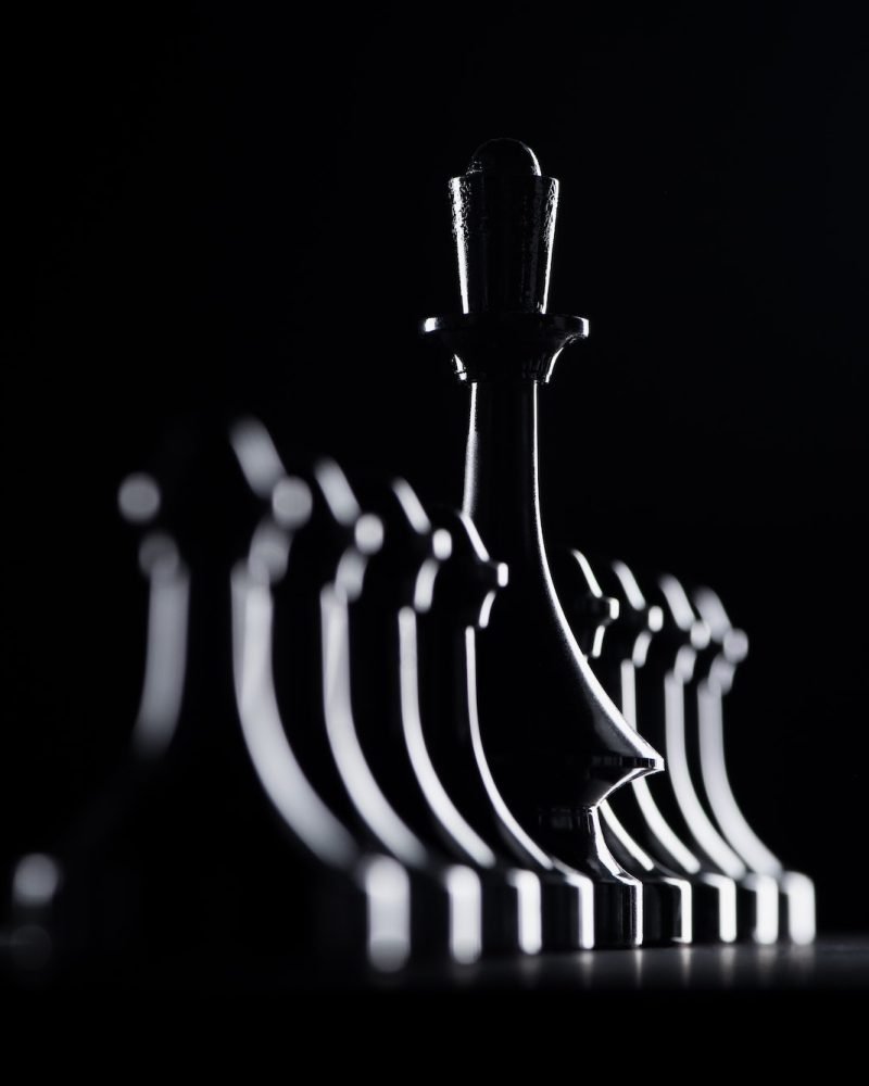 silhouettes-of-chess-pawns-and-queen-isolated-on-black-business-concept.jpg